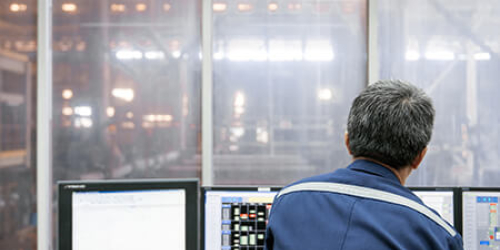 Engineer in control room using GE Digital industrial software with predictive analytics