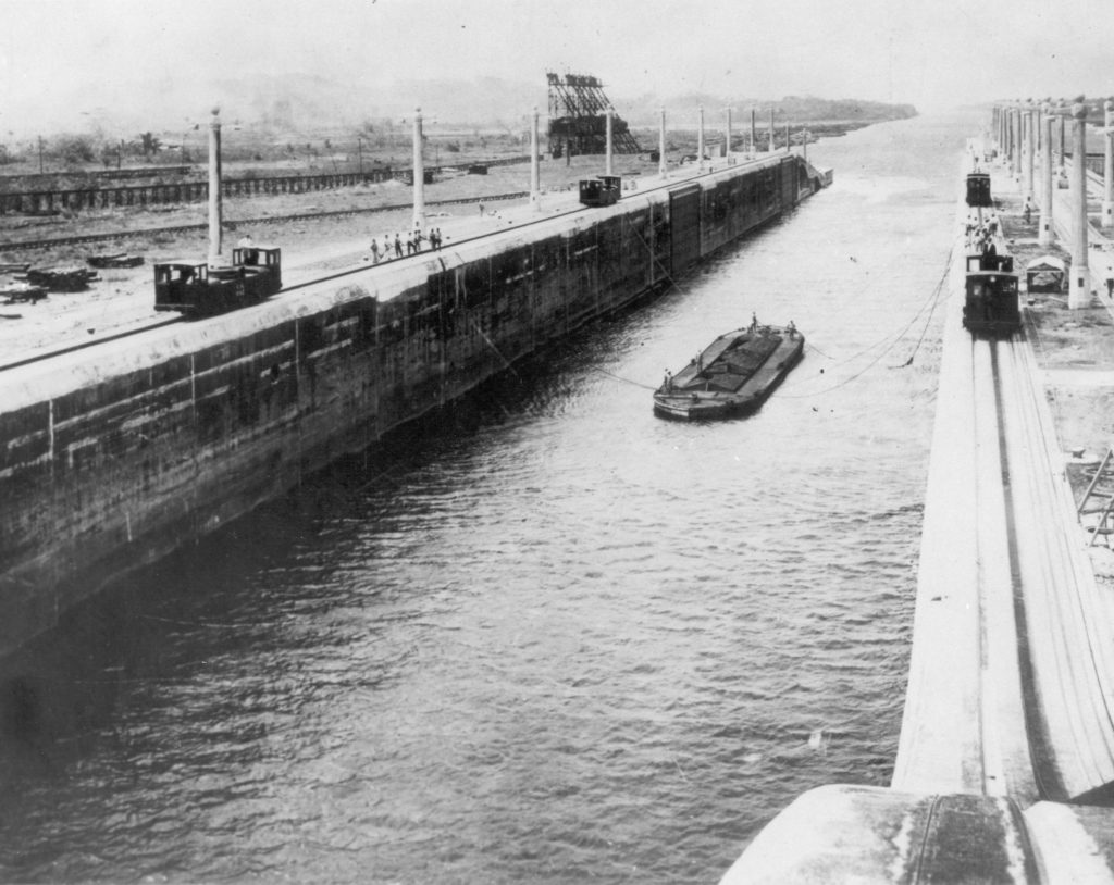 Towing locomotives ( electric mules) - first trial run returning barge through Gatun Locks to Atlantic Level, Panama Canal, 1914.