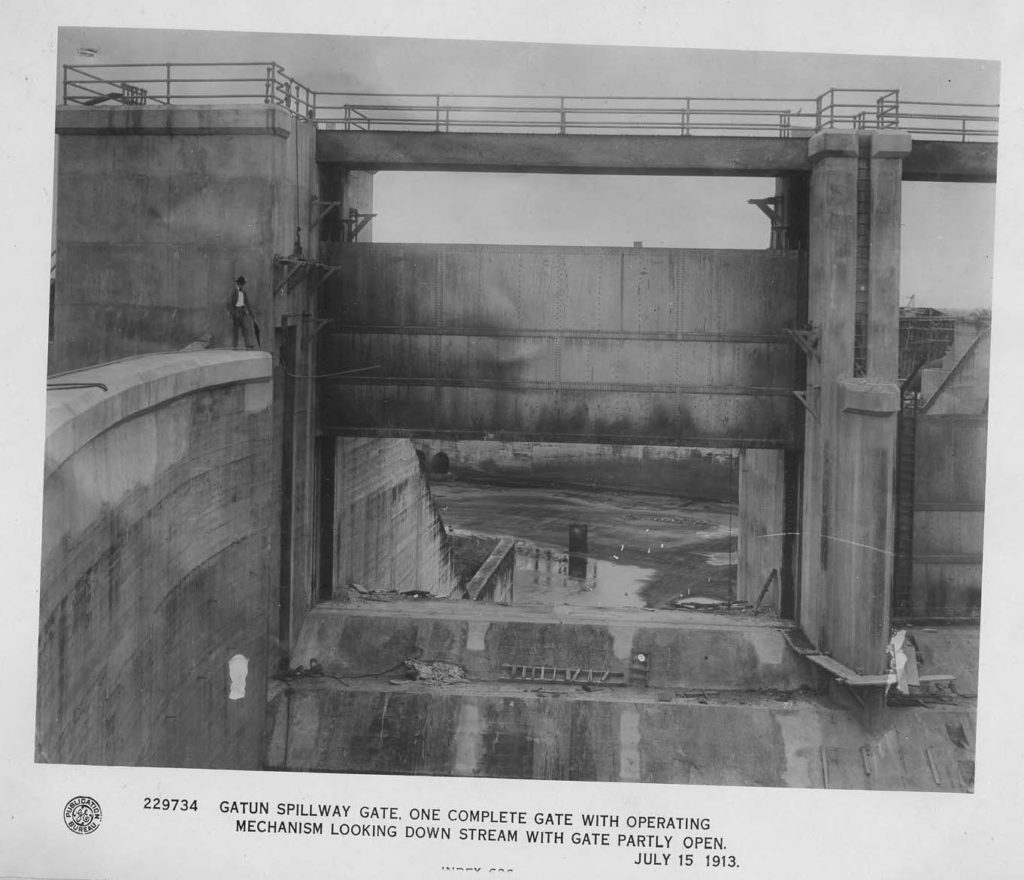229734 Man stands next to Gatun spillway gate, July 1913