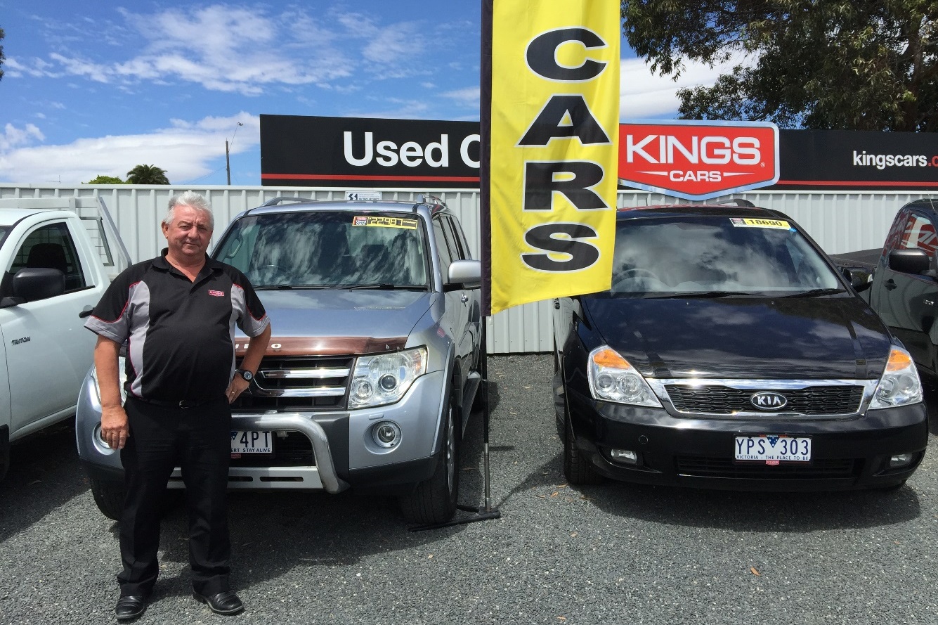  /><br />
<br />
“We kicked two goals straight away!” says John “Robbo” Robertson, sales consultant with Kings Cars, a flag-waving dealership with gleaming car bonnets turned to welcome drivers to Ararat as they enter the rural city on the Western Highway. “I sold two cars to Ararat Wind Farm, around early October—a Triton and a Pajero,” says Robbo. “We put all-terrain tyres on them, ’cause they want that bit of grip.”<br />
<br />
Robbo points out that direct sales of vehicles are just the start of a good thing when it comes to serving the needs of a new local development project. Cars need to be fitted with extras, they need servicing and petrol!<br />
<br />
This region of western Victoria where the foothills draft upward to the Great Dividing Range boasts some of the country’s best wind resources, and Robbo wakes up each day to a view of the turbines of an existing nearby wind farm. “I reckon it’s an awesome sight,” he says. He’s glad to know that 14 more farming families will soon supplement their incomes by hosting Ararat Wind Farm turbines. “They’ve had a bad run,” he says of the drought that has cut deep into the farming economy. “Green Hill Lake is completely dry, there’s not a drop in it. And I’ve never seen Norval Dam so low in my entire life.”<br />
<br />
He leans forward on his desk to confide, “I’ve got a customer coming in today and I reckon he’s buying his car because his farm’s going to be drought proof. I’m not sure how many turbines he’s going to have, whether it’s seven or 11, but it’s good income for something spinning around. It really covers for bad years on the farm.”<br />
<h3>Building on local expertise</h3><br />
<h4><a href=