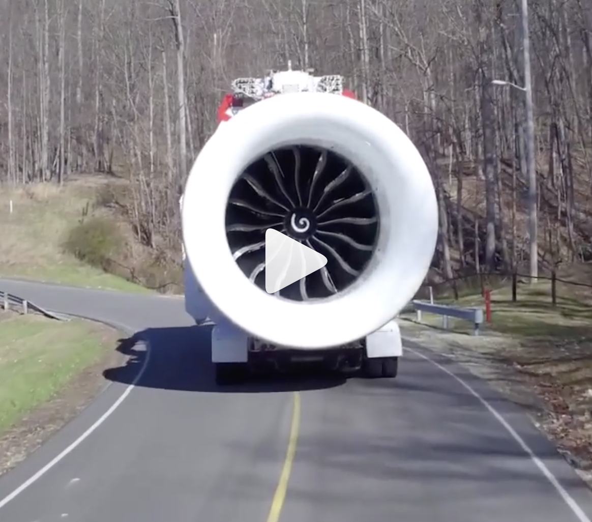 Screenshot of the GE9X being transported on a two-lane road