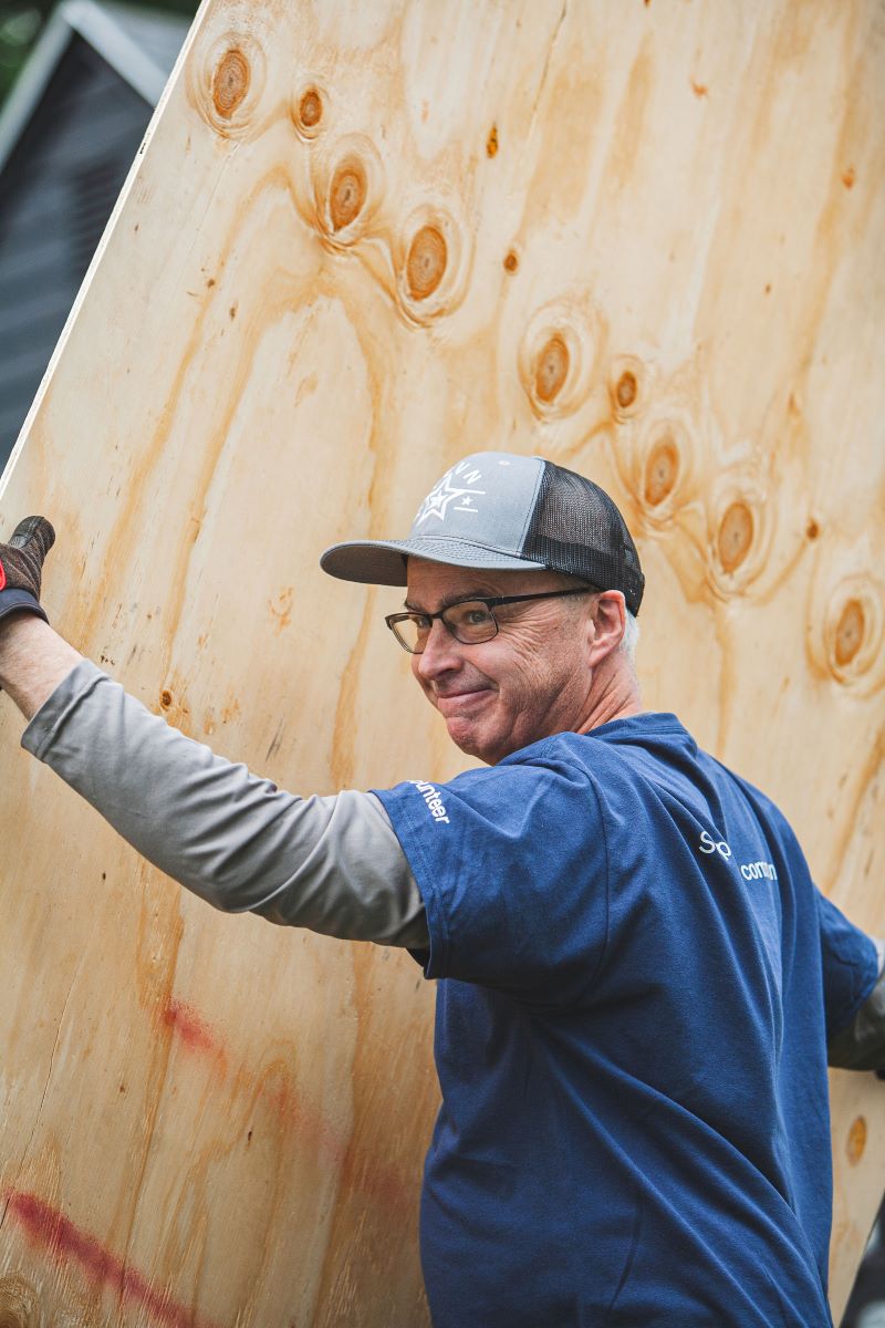 Man carrying a wooden plank