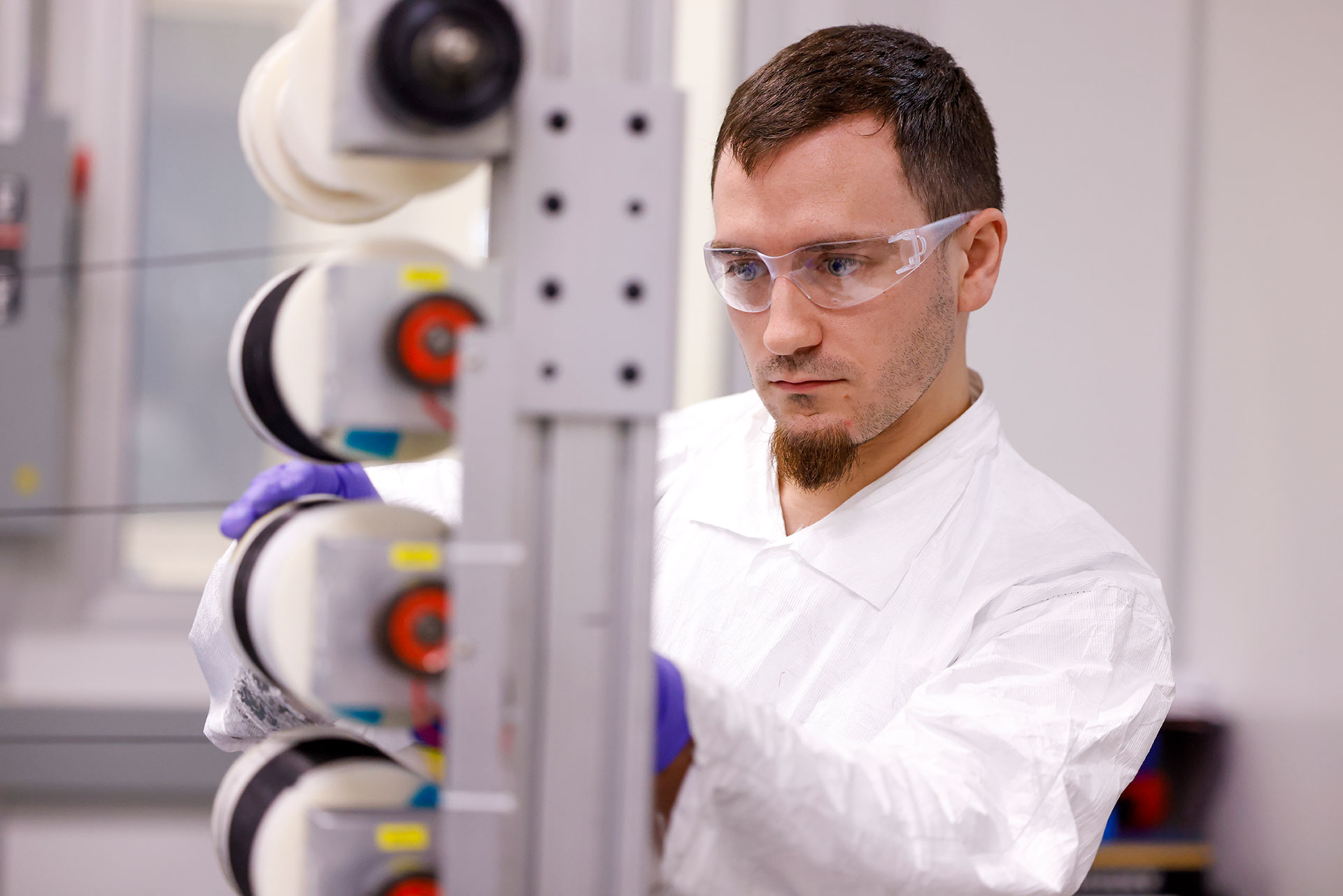 GE Aerospace lab specialist Dakota Martin inspects spools of Ceramic Matrix Composite fiber